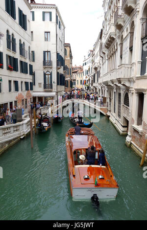 Les touristes à cheval les gondoles et les bateaux-taxis dans la ville de Venise, Italie Banque D'Images