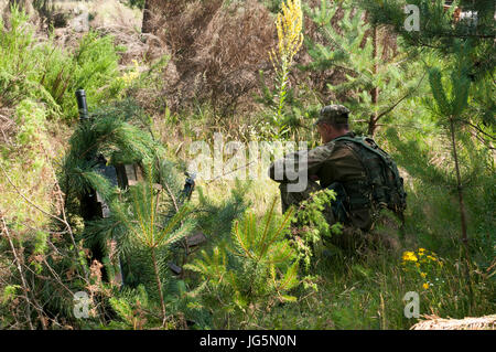 Un soldat avec l'Ukraine, 1ère Airmobile, 79e Brigade d'assaut aérien, prépare une arme lourde mise en place par l'utilisation de la dissimulation camouflage avant le début d'un bataillon à l'exercice de formation sur le terrain de combat de Yavoriv Centre de formation sur le maintien de la paix et la sécurité internationale, près de l'viv, Ukraine, le 29 juin. Le personnel de la CCT de Yavoriv, avec des mentors de l'armée américaine 45th Infantry Brigade Combat Team, a dirigé la formation des soldats du 1er Bataillon, 79e regt. pendant la rotation du bataillon par le CCT de Yavoriv. La 45e est déployée à l'Ukraine, au sein de la Force multinationale de T Banque D'Images