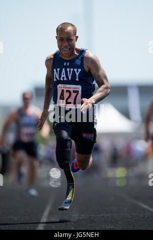 Le Maître de 2e classe de la marine Alan Thomas franchir la ligne d'arrivée du 100 mètres au cours de la Ministère de la Défense 2017 Warrior Jeux à Lane Technical College Preparatory High School de Chicago, 2 juillet 2017. La DoD Warrior Jeux sont un événement annuel permettant aux blessés, malades et blessés militaires et anciens combattants à la concurrence dans les sports paralympiques-style. (DoD photo par EJ Hersom) Banque D'Images