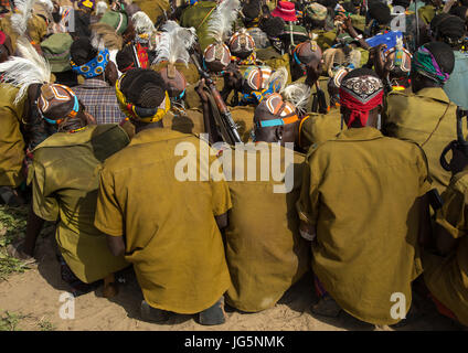 Les guerriers de la tribu au cours de la cérémonie à l'ox fière tribu Dassanech en attente de partager la viande de vache, comté de Turkana, Omorate, Ethiopie Banque D'Images