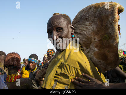 Vieil homme portant un gros morceau de viande de vache pendant la cérémonie à ox fière tribu Dassanech, comté de Turkana, Omorate, Ethiopie Banque D'Images