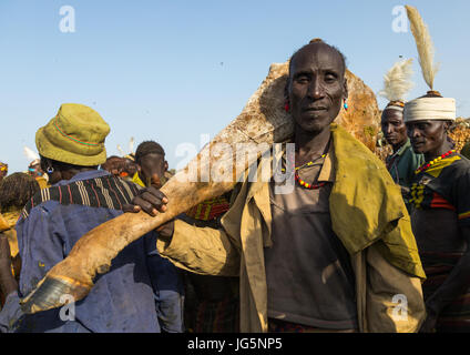 Vieil homme portant un gros morceau de viande de vache pendant la cérémonie à ox fière tribu Dassanech, comté de Turkana, Omorate, Ethiopie Banque D'Images