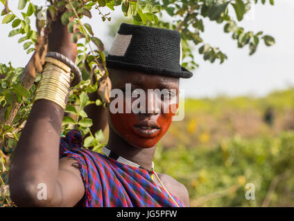 Belle jeune femme avec un chapeau et un peu de graisse au cours de la cérémonie d'hommes dans la tribu Bodi, vallée de l'Omo, Hana Mursi, Ethiopie Banque D'Images