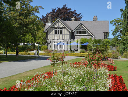 Bâtiment historique appelé la Maison du Conservateur situé dans le Jardin botanique de Christchurch au milieu de l'été. Banque D'Images