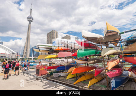 Toronto, Canada - 26 juin 2017 : étagères de couleurs vives des kayaks et des canots à Toronto Waterfront en été, avec la Tour du CN à l'arrière-plan Banque D'Images