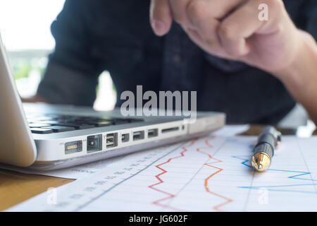 Businessman working on Photo bureau loft moderne. Homme assis et de tables en bois à l'aide de l'ordinateur portable contemporain, sms message clavier. Banque D'Images