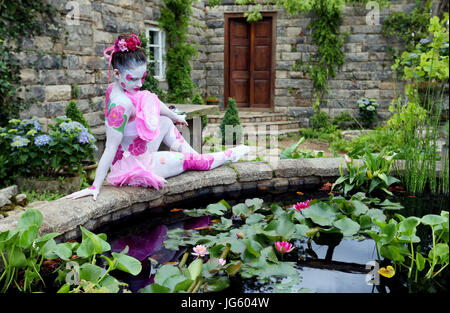 Un modèle peint comme une fleur de camélia dans le Jardin Secret du Pazo au cours de la journée consacrée à la RHS Hampton Court Palace Flower Show 2017 à Hampton Court, à Londres. Banque D'Images