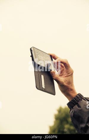 Main mâle holding phone vers le haut tout en faisant une photo Banque D'Images