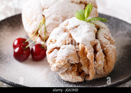 Gâteau sablé snowball avec une cerise sur une plaque horizontale de près. Banque D'Images