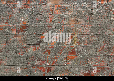 Mur de brique couverte en partie avec du ciment. La texture de fond. Banque D'Images