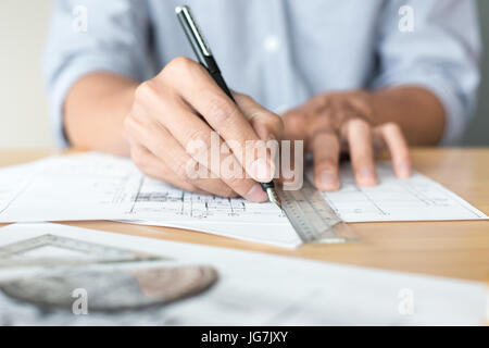 Architecte créatif projetant sur les grands dessins dans l'obscurité bureau loft ou café avec dark et retro style Banque D'Images