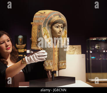 London,UK,4 Juillet 2017,un Photocall a eu lieu avant la Vente Bonhams Antiquities jeudi. Le spectacle : un masque de sarcophage en bois polychrome égyptien Nouveau Kingdom-Third Période intermédiaire, 19th-21st dynastie, circa 1292-945 B.C. représentant le défunt dans une perruque tripartite à plumes de motifs floraux et d'un scarabée sur le front, et un large collier de perles, détails en noir, rouge, bleu, vert, jaune et blanc, 48cm de haut©Keith Larby/Alamy Live News Banque D'Images