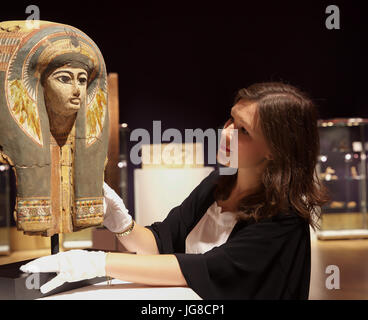 London,UK,4 Juillet 2017,un Photocall a eu lieu avant la Vente Bonhams Antiquities jeudi. Le spectacle : un masque de sarcophage en bois polychrome égyptien Nouveau Kingdom-Third Période intermédiaire, 19th-21st dynastie, circa 1292-945 B.C. représentant le défunt dans une perruque tripartite à plumes de motifs floraux et d'un scarabée sur le front, et un large collier de perles, détails en noir, rouge, bleu, vert, jaune et blanc, 48cm de haut©Keith Larby/Alamy Live News Banque D'Images