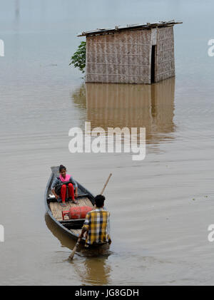 (170704) -- GUWAHATI (Inde), 4 juillet 2017 (Xinhua) -- Les résidants traverser une zone inondée par bateau à Panikhaiti, sur la ourskirts de Guwahati, dans le nord-est de l'état indien de l'Assam, le 4 juillet 2017. Pluie continue depuis la semaine dernière a frappé des lieux différents du nord-est de l'Inde, causant des inondations et des glissements de terrain. (Xinhua/Stringer) Banque D'Images