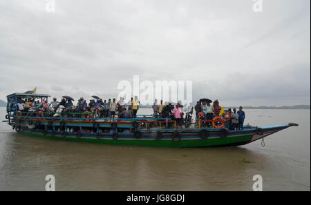 (170704) -- GUWAHATI (Inde), 4 juillet 2017 (Xinhua) -- Les résidants traversent la rivière Brahmaputra inondées par ferry à Guwahati, dans le nord-est de l'état indien de l'Assam, le 4 juillet 2017. Pluie continue depuis la semaine dernière a frappé des lieux différents du nord-est de l'Inde, causant des inondations et des glissements de terrain. (Xinhua/Stringer) Banque D'Images