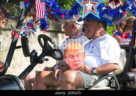 Sullivan's Island, Caroline du Sud, USA. 4 juillet, 2017. Un homme âgé rides avec un masque de Donald Trump à l'assemblée annuelle de Sullivan's Island Indépendance Day Parade le 4 juillet 2017 à Sullivan's Island, Caroline du Sud. La petite île de la mer d'abondance accueille une location de chariot de golf et défilé dans le village historique. Credit : Planetpix/Alamy Live News Banque D'Images