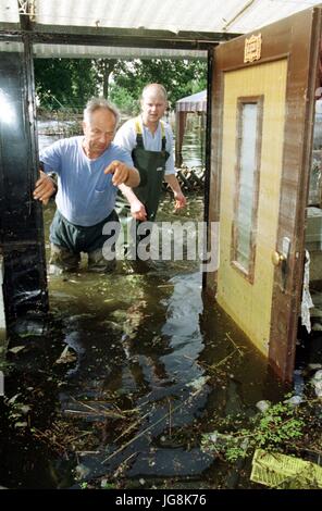 ARCHIVE - Werner Teidel (L) et son fils Lutz jetez un oeil sur les effets de l'inondation de leur maison à l'Thaelmann housing estate près de Zilkendorf au sud de Francfort (Oder), Allemagne, 26 juillet 1997. 20 ans après l'inondation du siècle' à la rivière Oder le danger d'une très grande marée de rivières dans la région n'est pas évitée. Photo : Andreas Altwein/dpa Banque D'Images