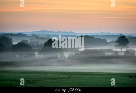 Firle, East Sussex. 5 Juillet 2017 : Le soleil se lever plus de brume du matin dans les régions rurales de l'East Sussex, sur ce qui promet d'être un jour chaud et ensoleillé. ©Peter Cripps/Alamy Live News Banque D'Images