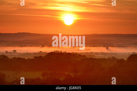Firle, East Sussex. 5 Juillet 2017 : Le soleil se lever plus de brume du matin dans les régions rurales de l'East Sussex, sur ce qui promet d'être un jour chaud et ensoleillé. ©Peter Cripps/Alamy Live News Banque D'Images