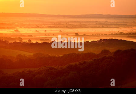 Firle, East Sussex. 5 Juillet 2017 : Le soleil se lever plus de brume du matin dans les régions rurales de l'East Sussex, sur ce qui promet d'être un jour chaud et ensoleillé. ©Peter Cripps/Alamy Live News Banque D'Images