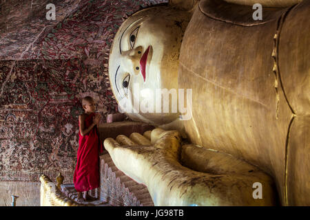 Moine novice bouddhiste / little monk / jeune moine culte belle grande statue de Bouddha couché dans Phowintaung Monywa Myanmar cave Banque D'Images