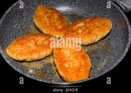 Des cakes avec une croûte dorée frit dans une casserole. Banque D'Images