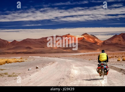 L'homme le vélo sur la route de sable ondulé à travers l'Altiplano en Bolivie Banque D'Images