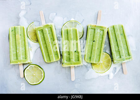 Le Mojito, le yogourt et les popsicles de chaux sur des cubes de glace. L'été en bonne santé et rafraîchissant dessert Banque D'Images