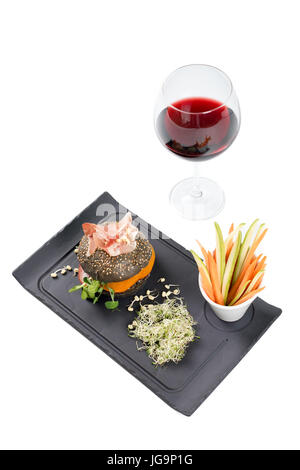 Burger sain avec hamon, tomates, pousses et noir, petits pains à grains entiers de bâtonnets de légumes et de vin rouge à l'ardoise noire sur fond blanc. Nettoyer, alimentaires, les régimes alimentaires detox concept. Banque D'Images