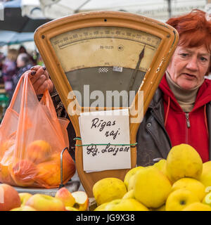 RIGA, Lettonie - CIRCA MAI 2014 : Merchant vendre des pommes dans le marché central de Riga Banque D'Images