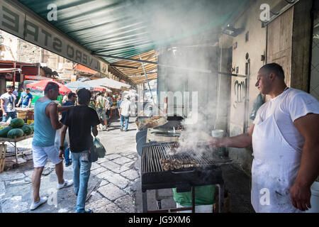 De vendeurs d'aliments de rue dans le marché Ballaro dans l'Albergheria, dans le centre de Palerme, Sicile, Italie. Banque D'Images