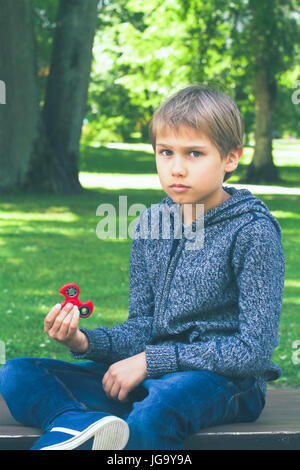 Garçon avec un spinner fidget outdoors Banque D'Images