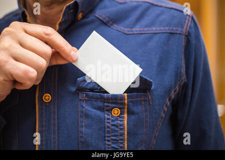 Carte bancaire, carte d'affaires, homme d'affaires en shirt tenant une carte, de retour dans sa poche de chemise Banque D'Images