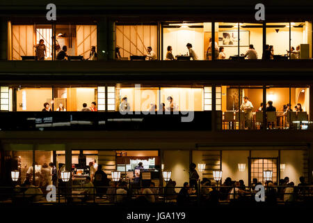 Le restaurant multi-couches sur les rives de la rivière Kamo (Kamo-gawa), avec les gens, manger de façon traditionnelle, Kyoto, Japon Banque D'Images