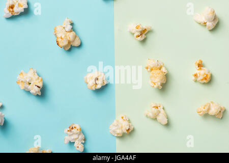 Le pop-corn dans tasse de papier sur fond bleu et vert. Banque D'Images