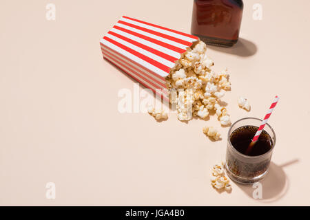 Maïs soufflé au carton rouge et blanc avec verre de soda Banque D'Images