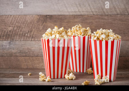 Popcorn en rouge et blanc carton sur table en bois. Banque D'Images