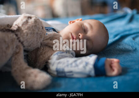 Cute baby boy sleeping with teddy bear Banque D'Images