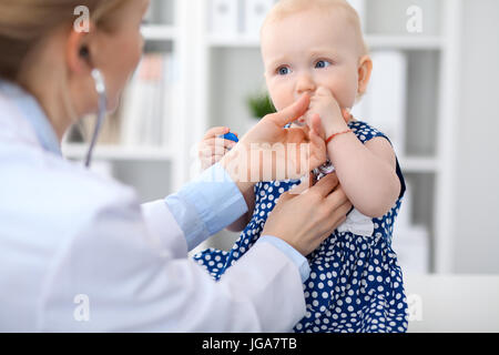 Pédiatre prend soin de bébé à l'hôpital. Petite fille est en cours d'examiner par doctor with stethoscope Banque D'Images