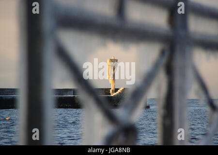 Un horizon de glaçons sur la lampe sur la jetée du port gelé de l'hiver. par la mer. Banque D'Images