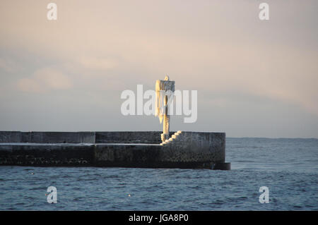 Un horizon de glaçons sur la lampe sur la jetée du port gelé de l'hiver. par la mer. Banque D'Images