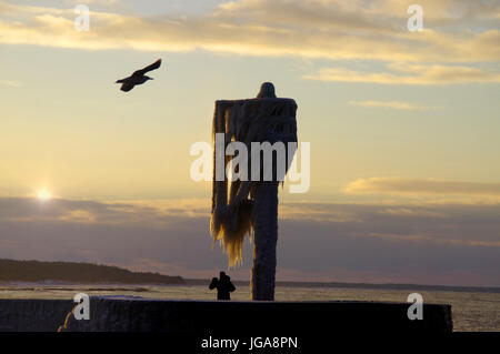 Un horizon de glaçons sur la lampe sur la jetée du port gelé de l'hiver. par la mer. Banque D'Images