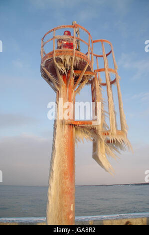 Toits de glaçons sur le port gelé lampe. hiver par la mer. Banque D'Images