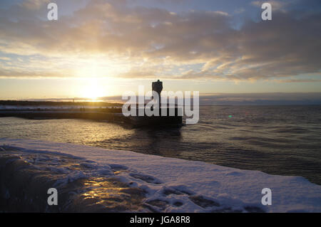 Un horizon de glaçons sur la lampe sur la jetée du port. L'hiver par la mer. Banque D'Images