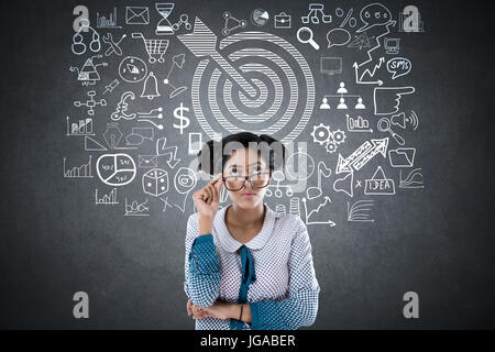 Choqué woman in front of blackboard avec dart cible et symbole Banque D'Images