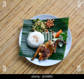 Riz au poulet balinais avec des feuilles de banane sur plancher en bois. Close up. Banque D'Images