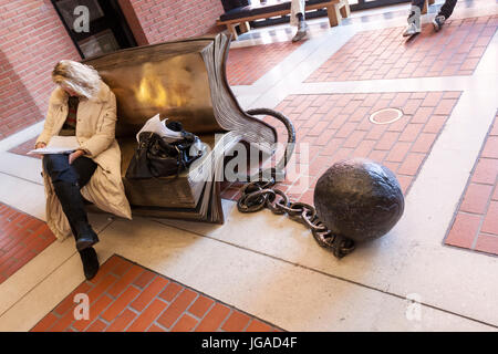 Coin du lecteur en bronze sculpture. Bill Woodrow's 'sitting sur l'histoire" à la British Library, bibliothèque nationale du Royaume-Uni, Londres, Banque D'Images