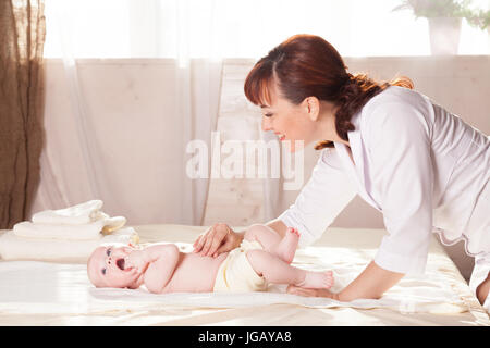 Le petit garçon baby doctor doing massage mains et jambes et dos Banque D'Images