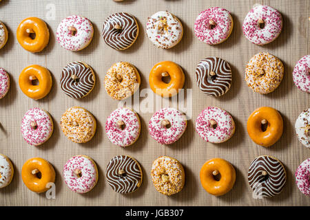 , Délicieux donuts colorés dans une rangée Banque D'Images
