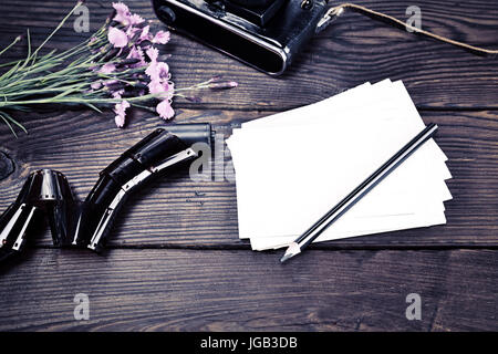 Cartes postales, vintage old camera et le bouquet d'Oeillets roses sur un fond de bois brun Banque D'Images